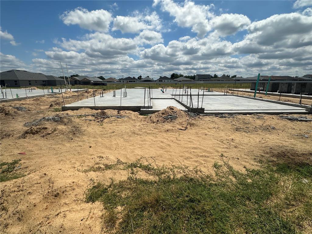 A concrete foundation slab for a new house sits on a sandy construction lot — 12539 NE 48TH TERRACE, OXFORD, FL