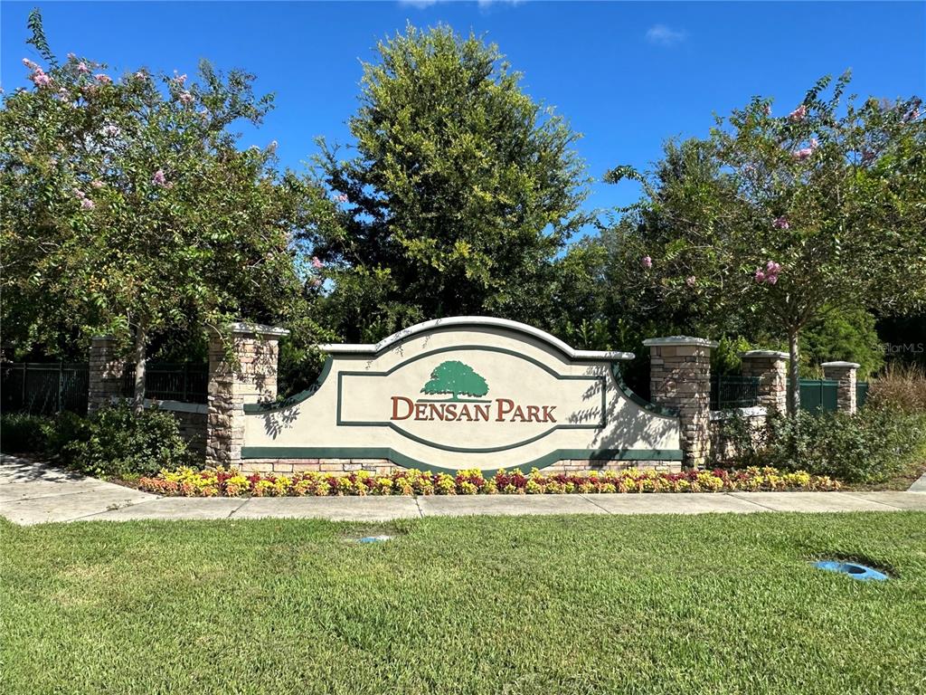 A stone and stucco monument sign for Densan Park stands in front of green trees — 12539 NE 48TH TERRACE, OXFORD, FL