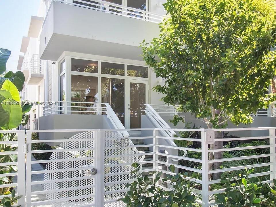A white modern building exterior features a gated entrance, stairs, and large glass windows — 619 Meridian Ave # 4, Miami Beach FL 33139, MIAMI BEACH, FL