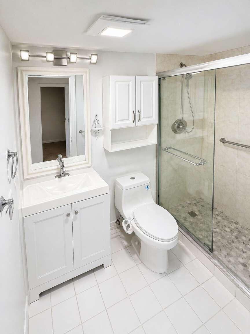 A white bathroom features a vanity, a toilet, and a glass-enclosed walk-in shower — 5160 Las Verdes Circle # 103, Delray Beach FL 33484, DELRAY BEACH, FL