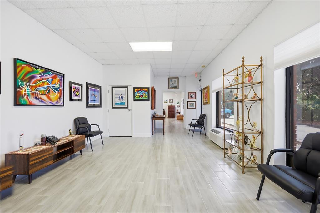 A waiting room with white walls, wood-look tile flooring, black chairs, and framed wall art — 30924 SUNEAGLE DRIVE UNIT Suite 201-203, MOUNT DORA, FL