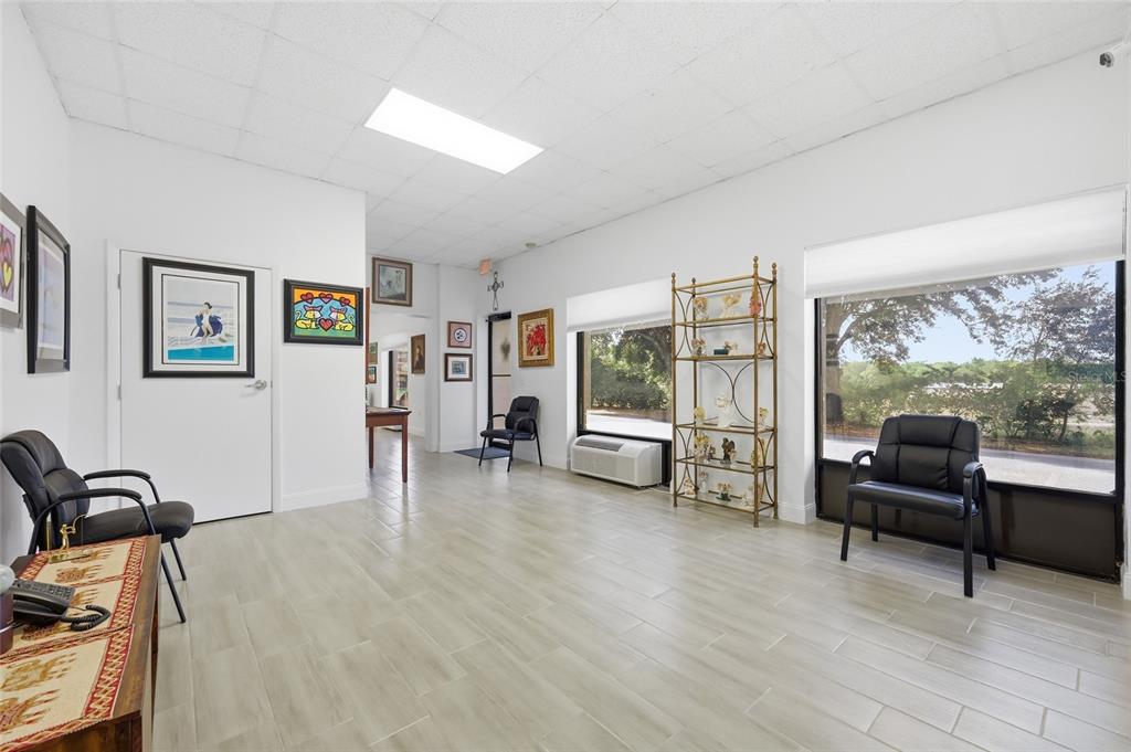 A bright waiting room features white walls, light tile flooring, large windows, and black chairs — 30924 SUNEAGLE DRIVE UNIT Suite 201-203, MOUNT DORA, FL