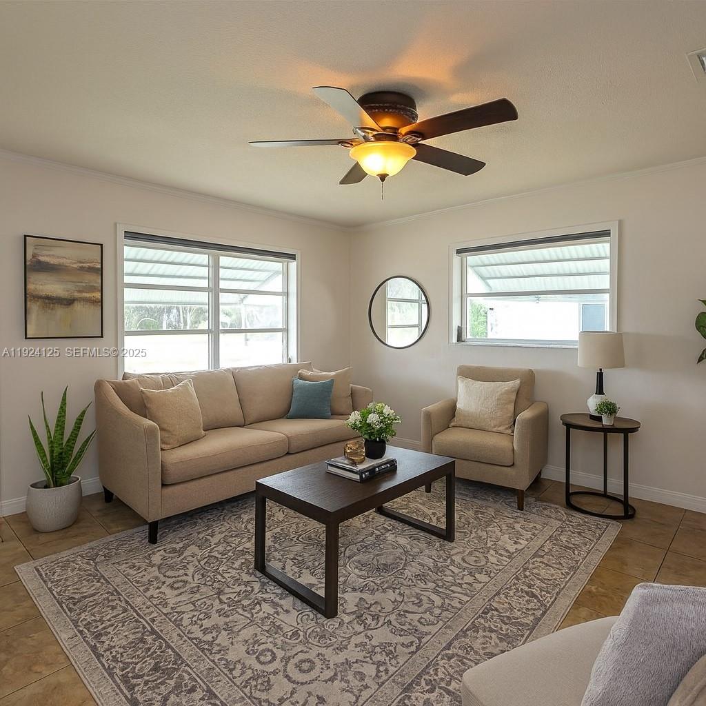 A living room features a white sofa, a television, a ceiling fan, and tile flooring — 1611 NW 46th St, Tamarac FL 33309, TAMARAC, FL