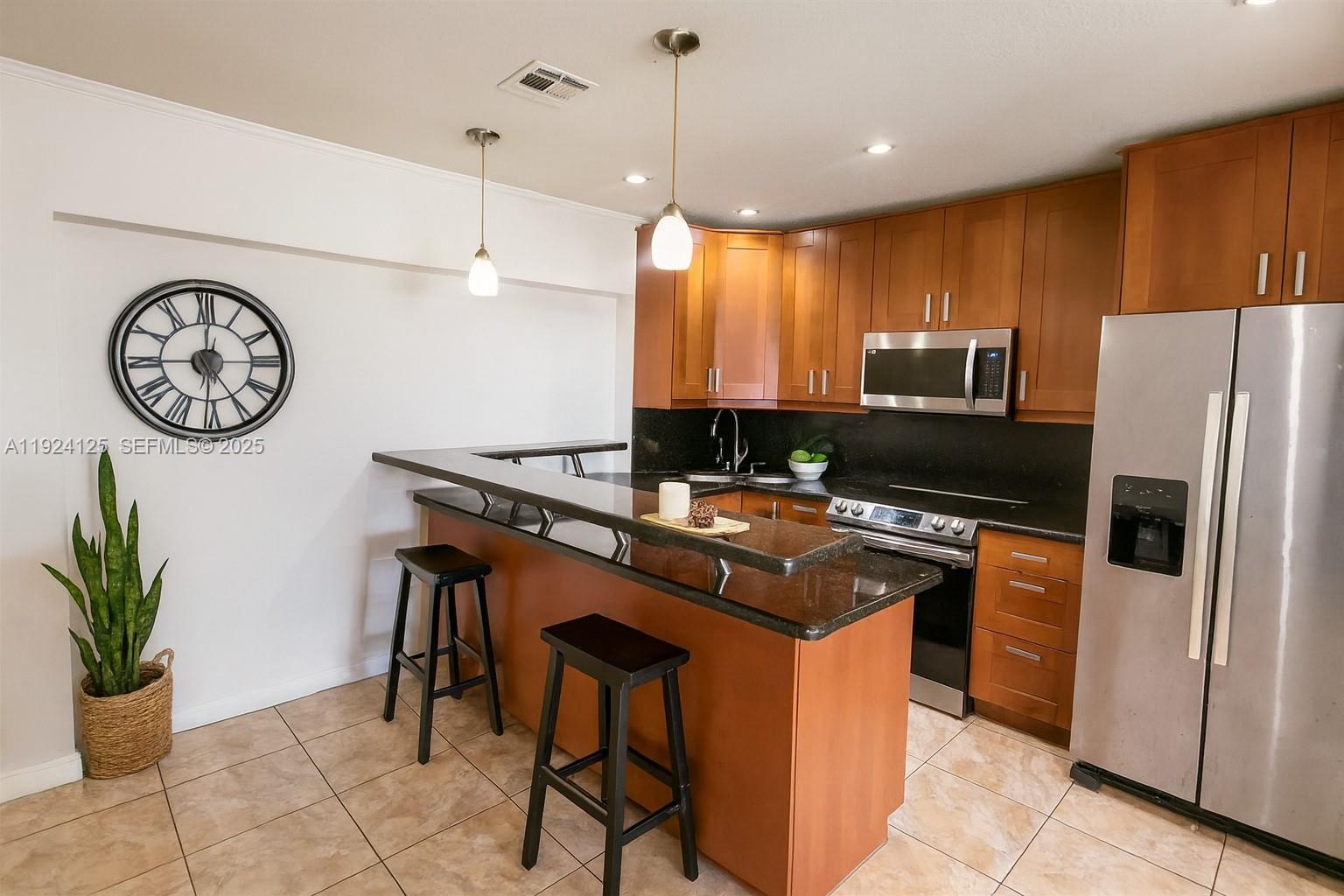 A hallway features tile flooring, a runner rug, a floor mirror, and a potted plant — 1611 NW 46th St, Tamarac FL 33309, TAMARAC, FL