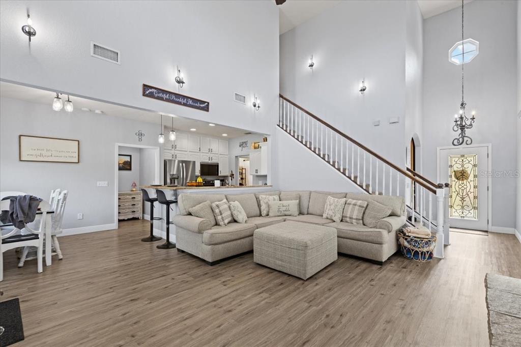 A living room with a sectional sofa, staircase, and an open kitchen with bar seating — 2600 SE 48TH AVENUE, TRENTON, FL