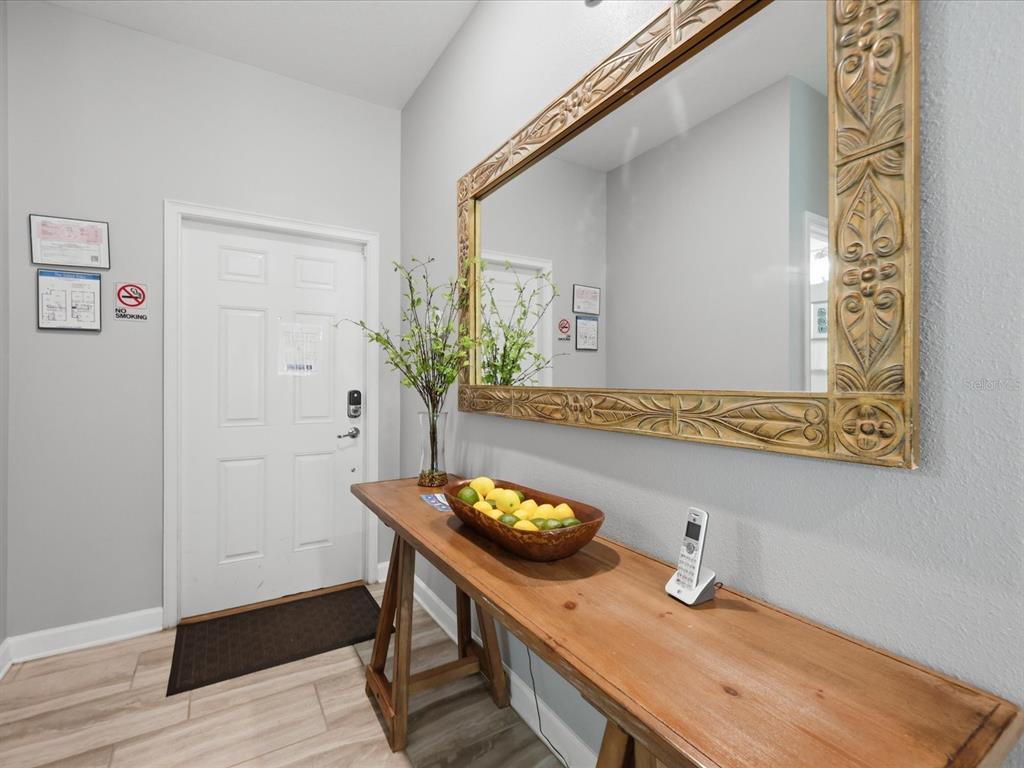 An entryway features a wooden console table, a large ornate mirror, and a white door — 1562 MOON VALLEY DRIVE, DAVENPORT, FL