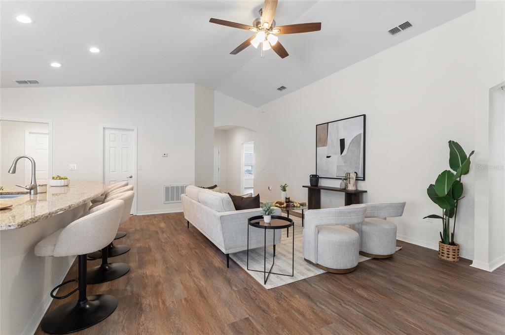 A living room with a kitchen island, light-colored furniture, and wood-look flooring — 2009 DANES COURT, LAKELAND, FL