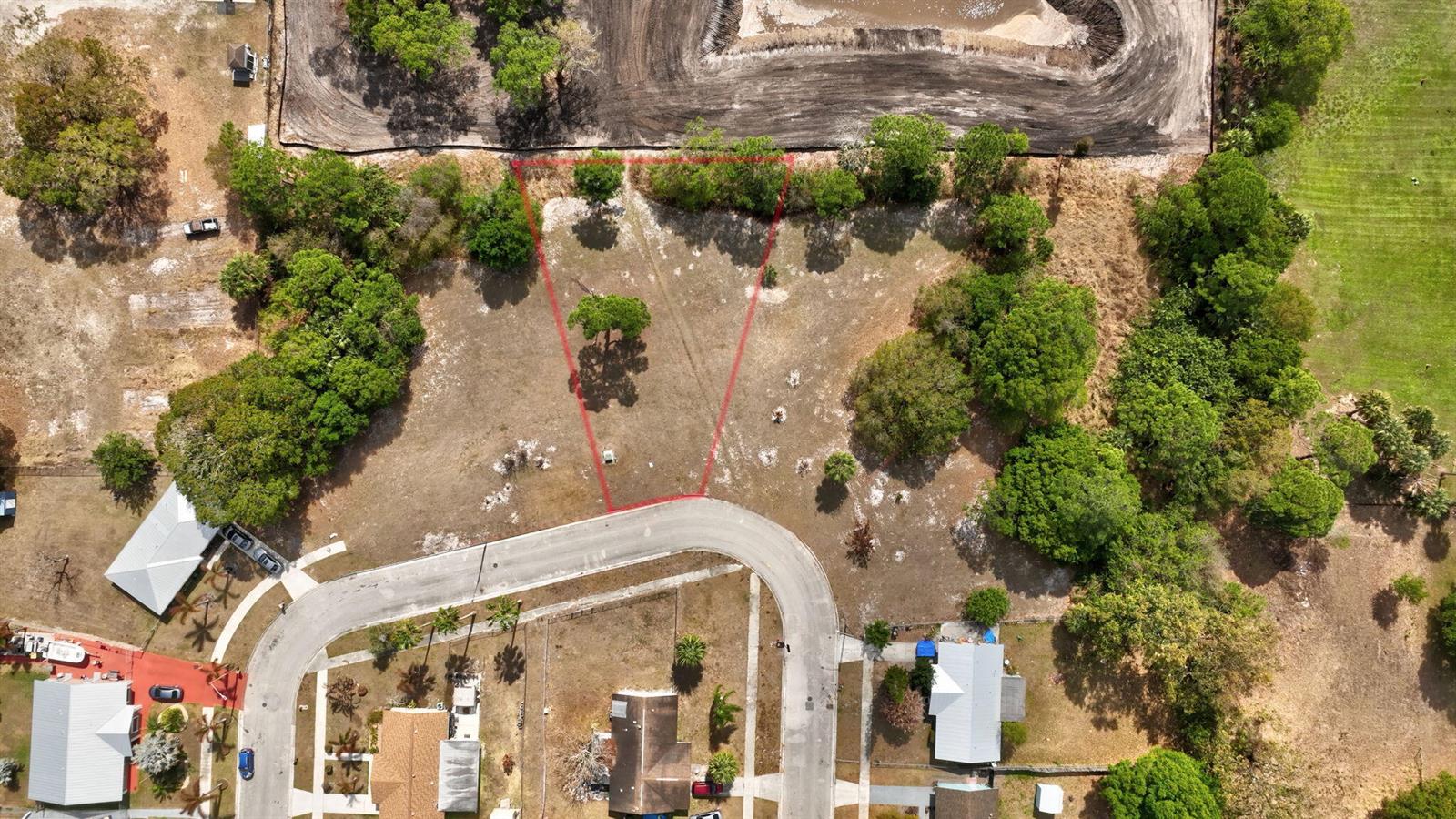 An aerial view shows a vacant, trapezoidal lot outlined in red within a residential neighborhood — 0 Hemlock Circle, Fort Pierce FL 34947, FORT PIERCE, FL