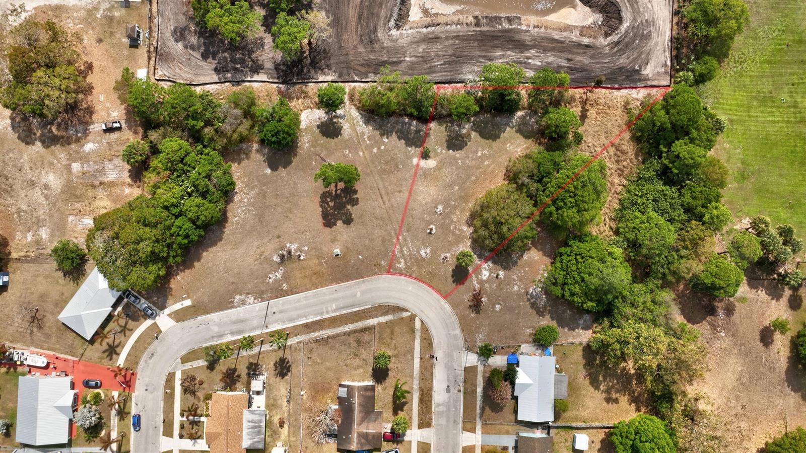 An aerial view shows a vacant, irregularly shaped residential lot bordered by trees and a road — 0 Hemlock Circle, Fort Pierce FL 34947, FORT PIERCE, FL