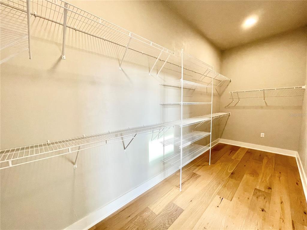 A walk-in closet features white wire shelving and light wood-look flooring — 122 SW 212TH DRIVE, NEWBERRY, FL