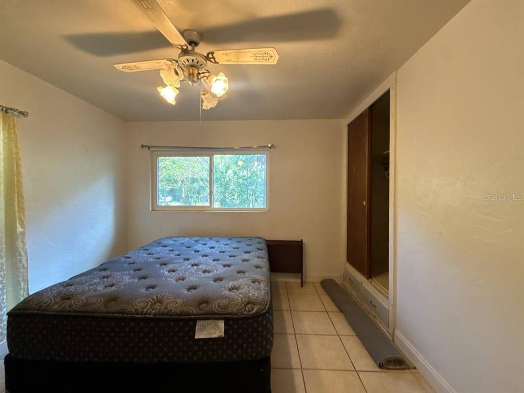 A bedroom features a mattress on a frame, a ceiling fan, and tiled flooring — 1032 NE 20TH AVENUE, GAINESVILLE, FL