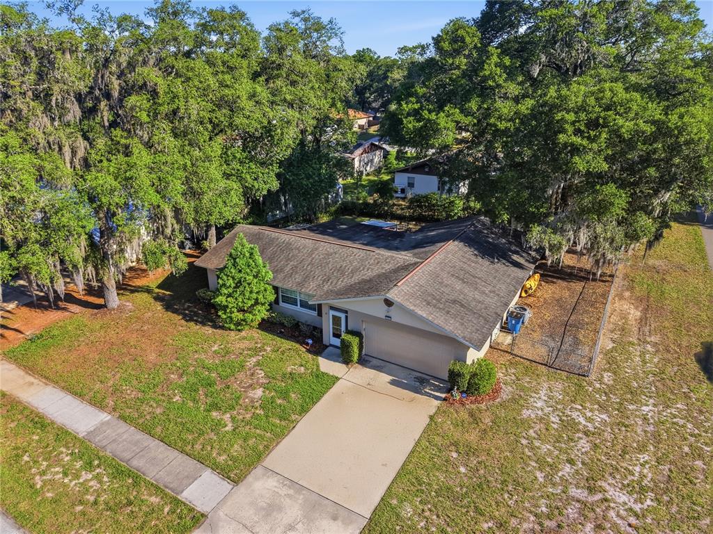 An aerial view shows a single-story house with a shingled roof and attached garage — 1111 HELEN DRIVE, DELAND, FL