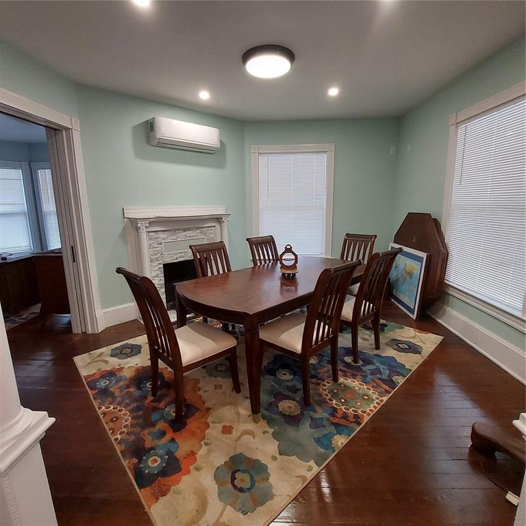 A dining room features a wooden table, chairs, an area rug, and a wall-mounted air conditioner — 331 W NEW YORK AVENUE, DELAND, FL