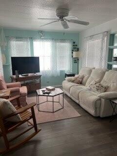 A living room features a white reclining sofa, a wooden rocking chair, and a television — 2430 SE Penny Lane, Stuart FL 34994, STUART, FL