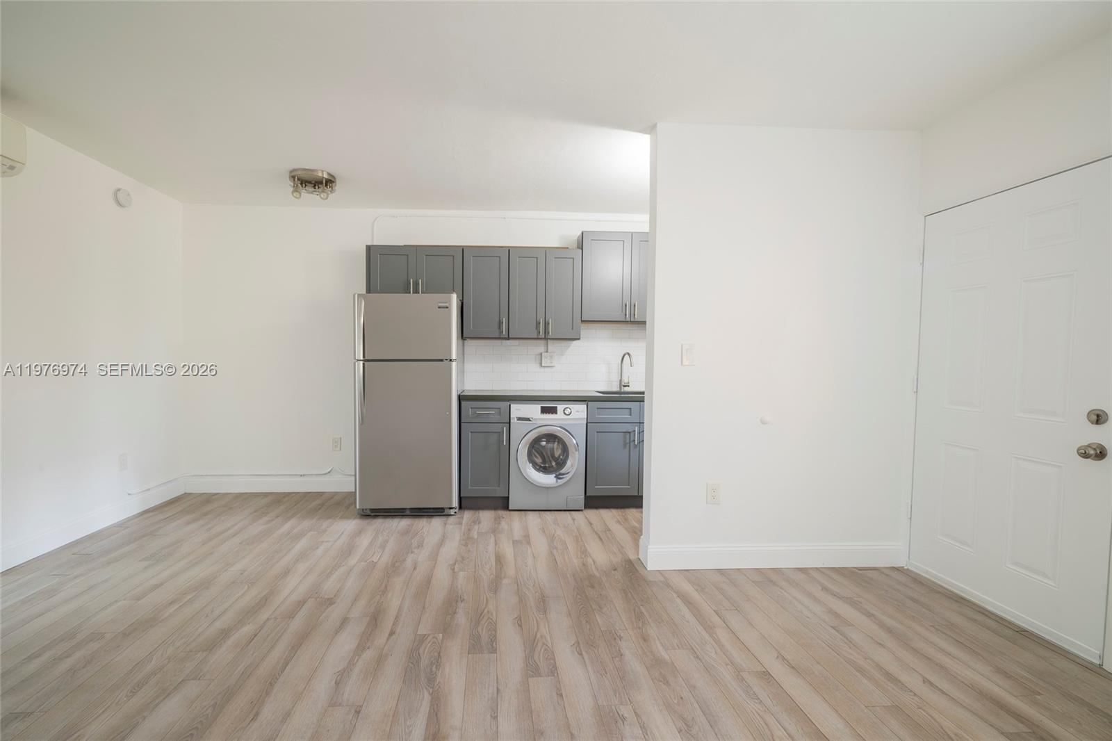 A small kitchen area features gray cabinets, stainless steel appliances, and light wood-look flooring — 7901 SW 64th Ave # 2, South Miami FL 33143, SOUTH MIAMI, FL