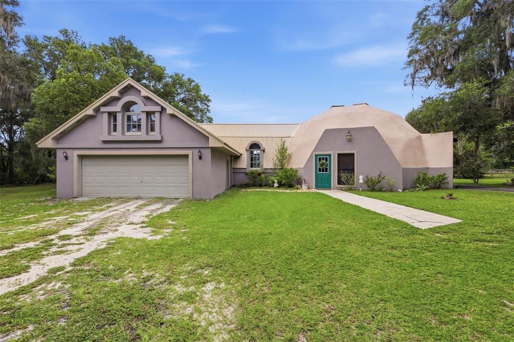 A unique house featuring a large dome structure attached to a traditional garage wing — 1320 W TAYLOR ROAD, DELAND, FL