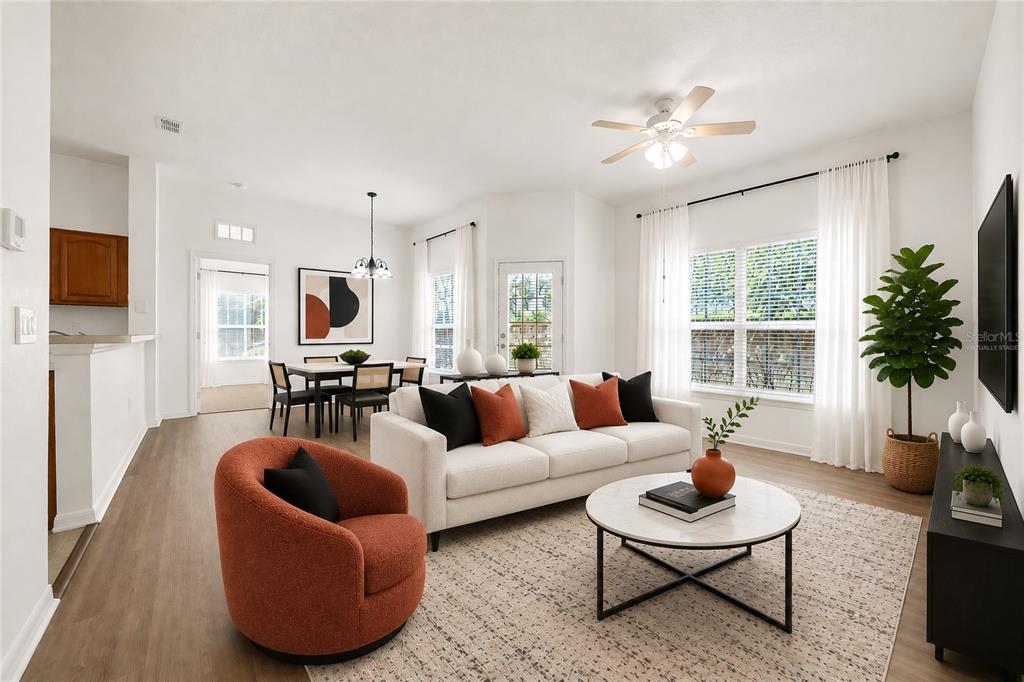 A living room and dining area feature light wood floors, white walls, and modern furniture — 970 N SPRING GARDEN AVENUE UNIT 212, DELAND, FL