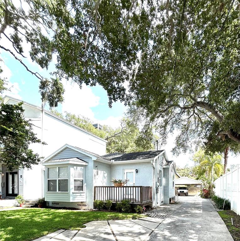 A light gray house features a bay window, a wooden deck, and double glass doors — 3014 W MASON STREET UNIT A, TAMPA, FL