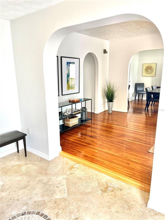 A tiled entryway leads through an arched opening into a dining area with hardwood floors — 3014 W MASON STREET UNIT A, TAMPA, FL