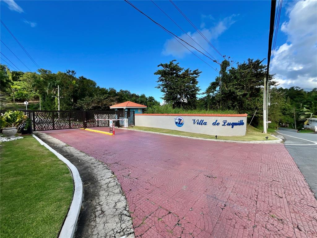 The entrance to Villa de Luquillo features a gated driveway with a paved road — Urb. Villas de Luquillo C 15, LUQUILLO, PR