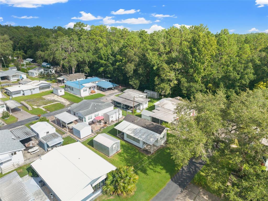 An aerial view shows several mobile homes with metal roofs situated near a wooded area — 2092 CULBREATH ROAD UNIT A27, BROOKSVILLE, FL