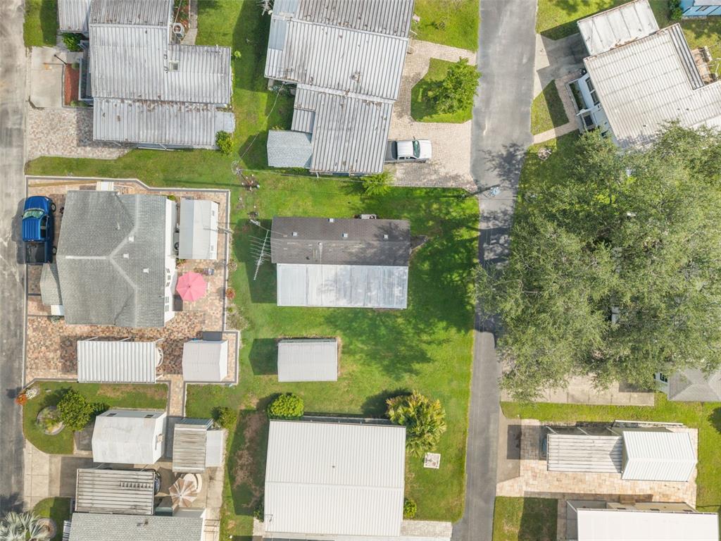An aerial view shows several residential buildings with metal roofs, paved driveways, and green lawns — 2092 CULBREATH ROAD UNIT A27, BROOKSVILLE, FL