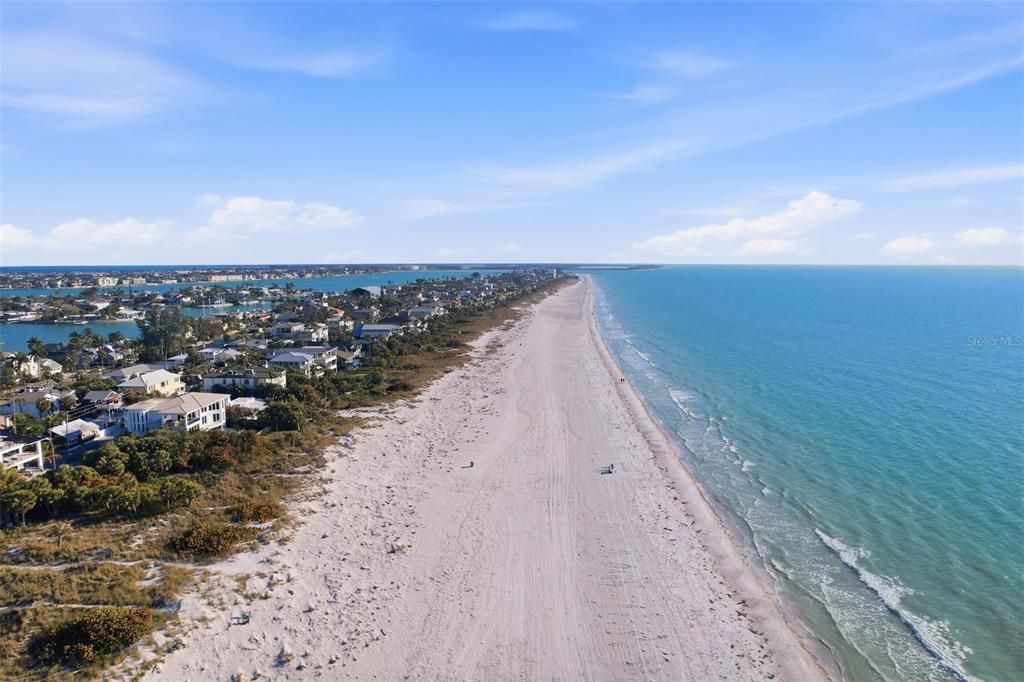 An aerial view shows a sandy beach bordering the ocean next to a residential neighborhood — 2906 PASS A GRILLE WAY, ST PETE BEACH, FL