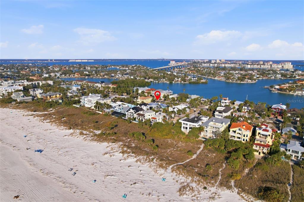 An aerial view shows a coastal neighborhood with houses situated along a sandy beach — 2906 PASS A GRILLE WAY, ST PETE BEACH, FL