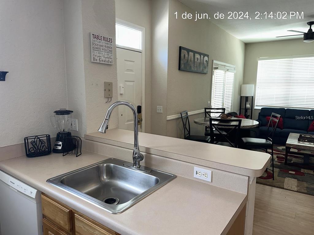 A kitchen sink and countertop overlook a dining area and living room — 4006 VENETIAN BAY DRIVE UNIT 108, KISSIMMEE, FL