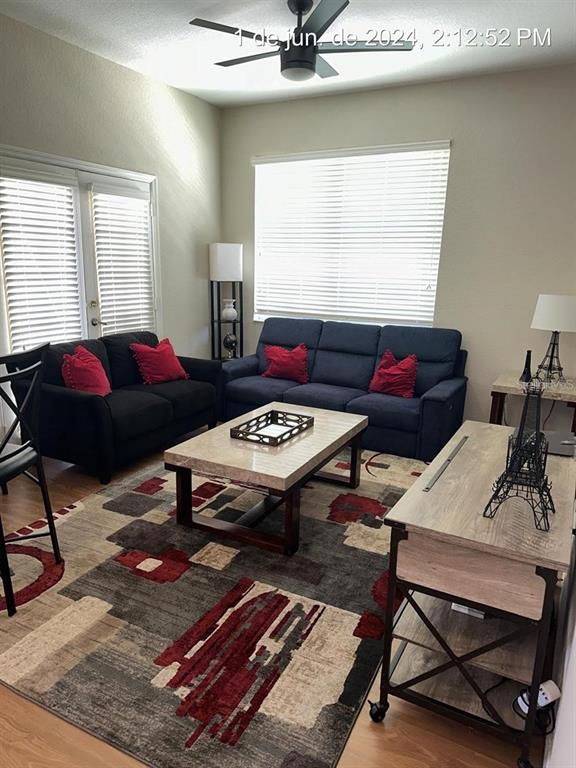 A living room features a dark sofa and loveseat, a coffee table, and a patterned rug — 4006 VENETIAN BAY DRIVE UNIT 108, KISSIMMEE, FL