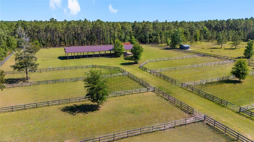 An aerial view shows a fenced horse pasture with a large open-sided barn — 13531 SE 54TH STREET, MORRISTON, FL