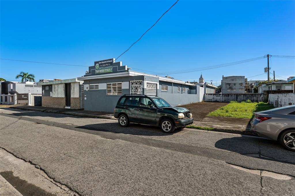 A street-level view of a gray commercial building with a parked car in front — #2 CALLE PADRE RIVERA WEST, HUMACAO, PR