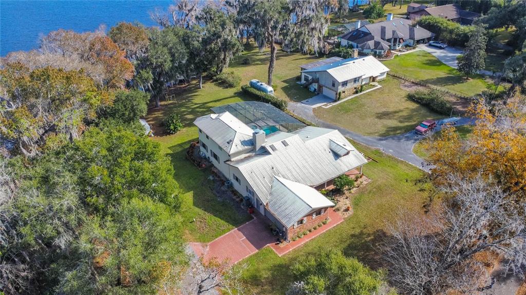 An aerial view shows a large house with a pool enclosure near a lake — 6121 S SUNWAY POINT, FLORAL CITY, FL