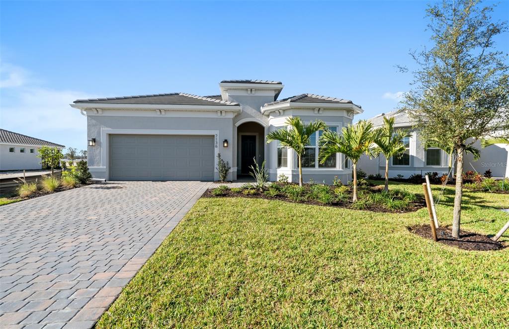 A single-story house with a paved driveway, a two-car garage, and a landscaped front yard — 7621 FULHAM AVENUE, BRADENTON, FL