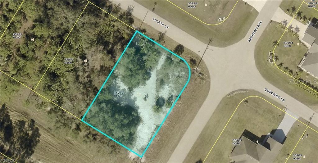 This is an aerial map showing a vacant, wooded corner lot outlined in blue — 601 LOLETA COURT, LEHIGH ACRES, FL