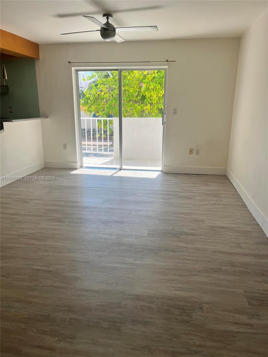 A living room features light wood-look flooring, a ceiling fan, and a sliding glass door — 240 Collins Ave # 2B, Miami Beach FL 33139, MIAMI BEACH, FL