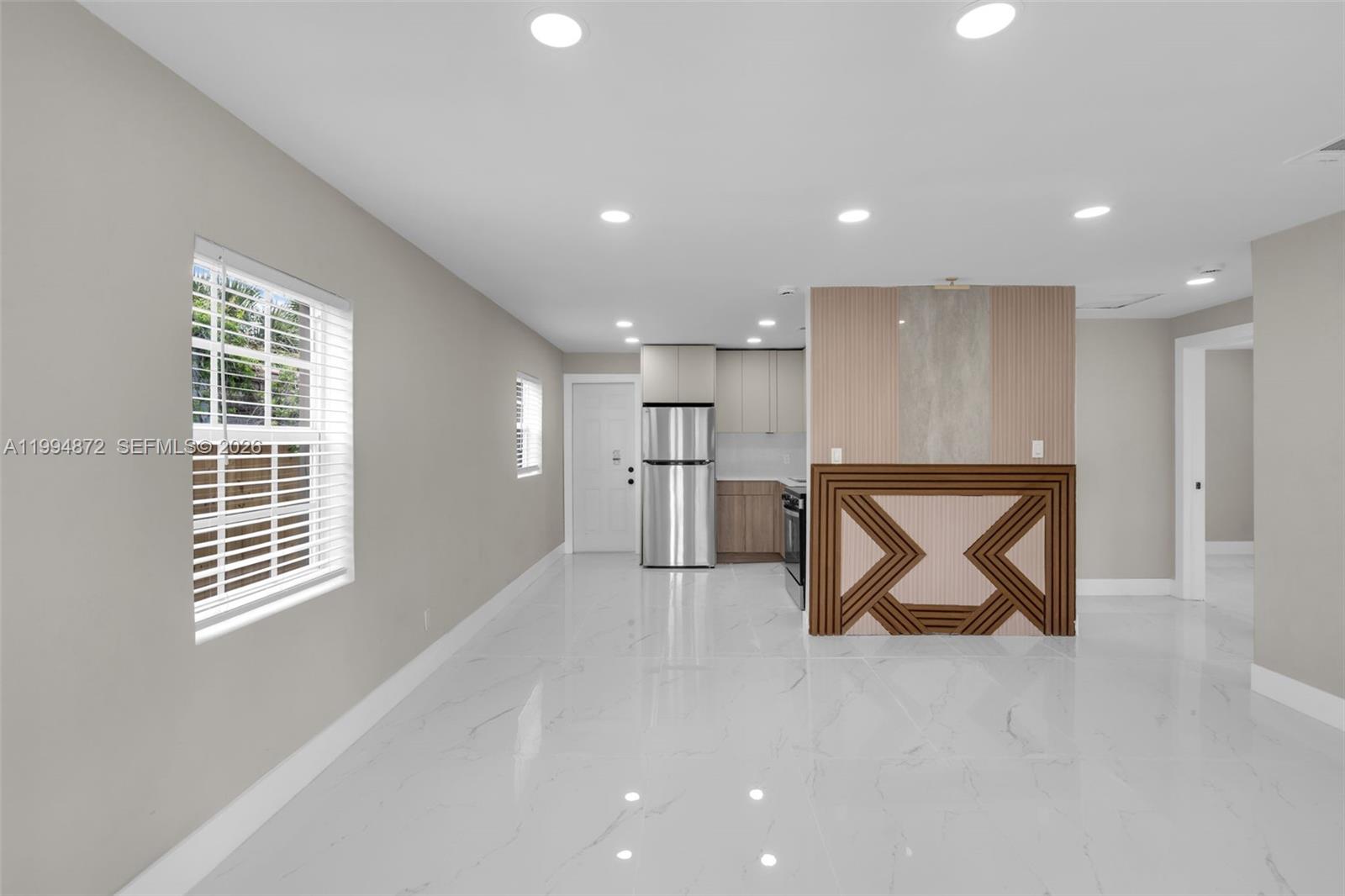 A kitchen with stainless steel appliances and a decorative wooden island sits in an open room — 1660 W 26th St, Riviera Beach FL 33404, RIVIERA BEACH, FL