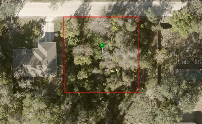 An aerial view shows a rectangular, tree-covered vacant lot outlined in red next to a house — 1424 10TH STREET, ORANGE CITY, FL