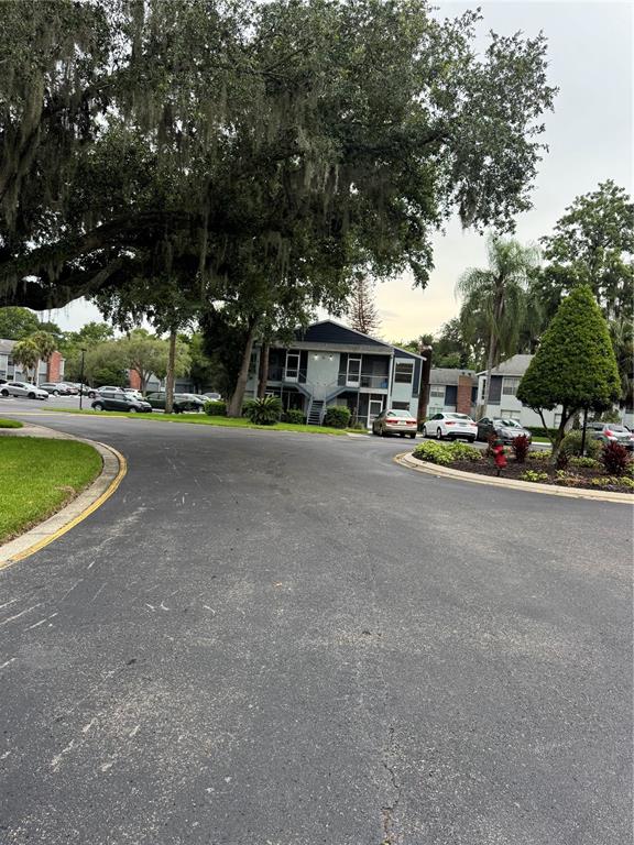 An exterior view of a multi-story apartment building with a parking lot and large trees — 408 NORTHLAKE DRIVE UNIT 0, SANFORD, FL