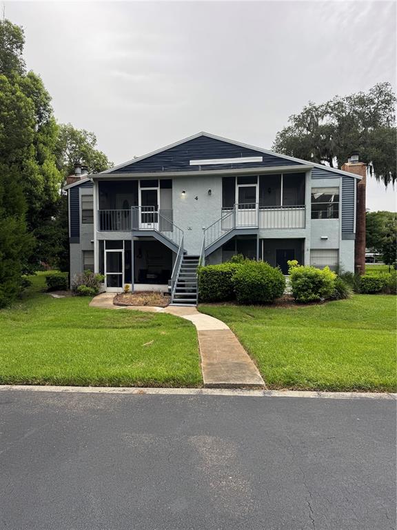 A two-story apartment building features screened porches, metal staircases, and a concrete walkway — 408 NORTHLAKE DRIVE UNIT 0, SANFORD, FL