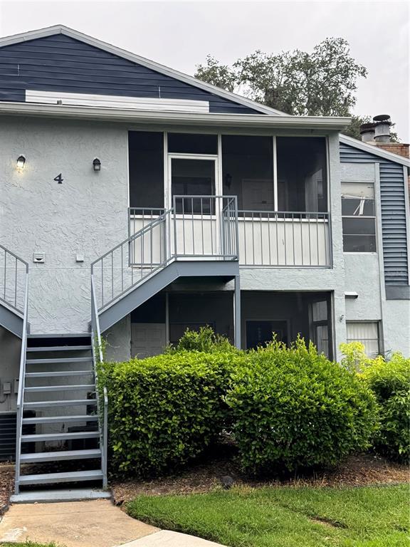 An exterior view of a two-story apartment building with a metal staircase and screened balconies — 408 NORTHLAKE DRIVE UNIT 0, SANFORD, FL