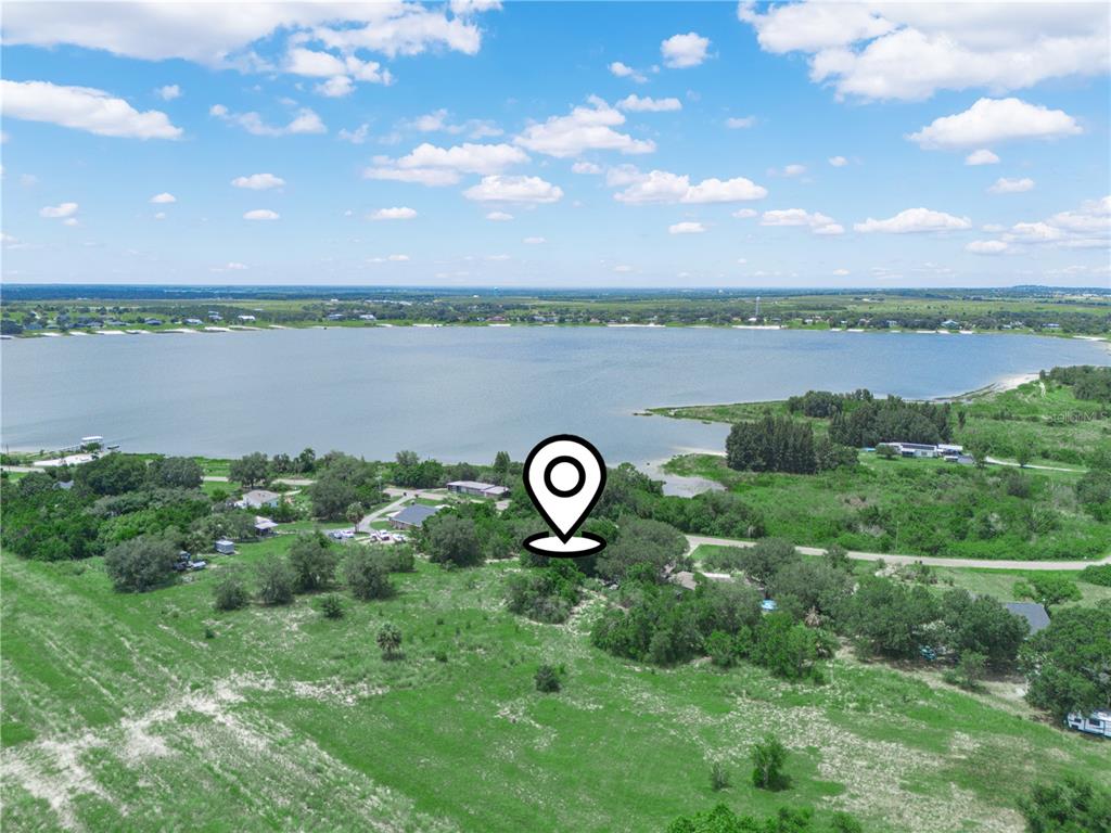 An aerial view shows a house near a large lake surrounded by trees and fields — 2370 LAKE EASY ROAD, BABSON PARK, FL