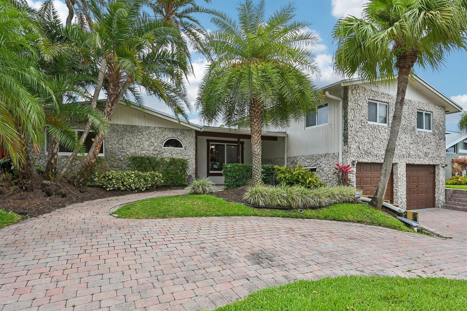 A two-story house with a stone facade, palm trees, and a brick paver driveway — 1232 NW 14th Street, Boca Raton FL 33486, BOCA RATON, FL