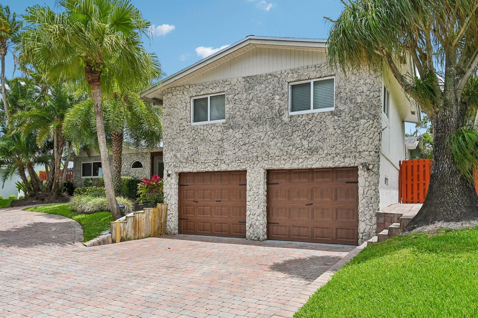 A two-story house features a stone facade, two brown garage doors, and a brick driveway — 1232 NW 14th Street, Boca Raton FL 33486, BOCA RATON, FL