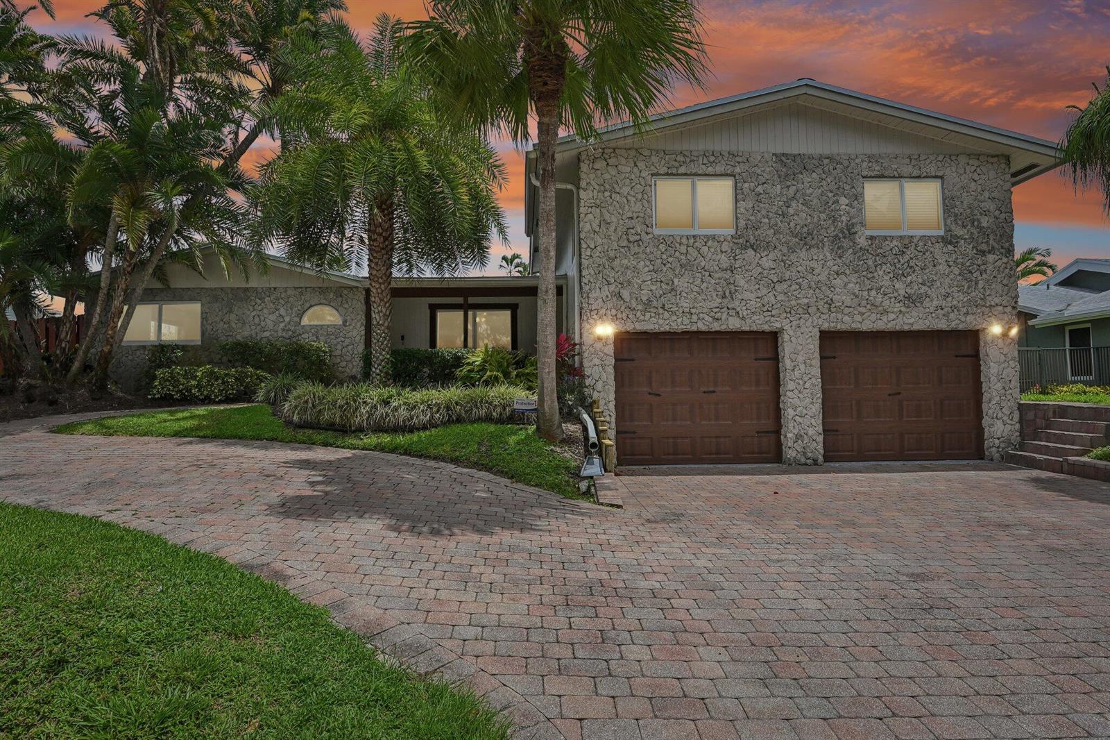 A two-story house with a stone facade, two garage doors, and a paved driveway — 1232 NW 14th Street, Boca Raton FL 33486, BOCA RATON, FL