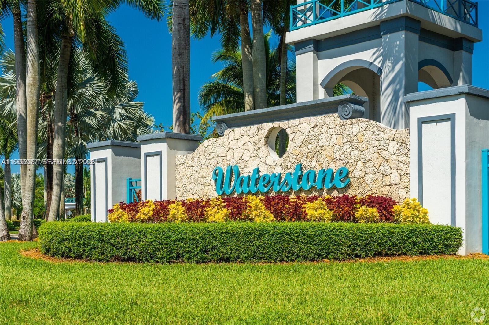 The entrance sign for Waterstone features a stone wall, landscaping, and a tall architectural tower — 1040 NE 42nd Pl, Homestead FL 33033, HOMESTEAD, FL
