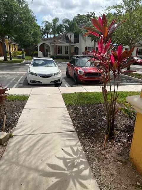 A white sedan and a red Mini Cooper are parked in front of a suburban house — 1040 NE 42nd Pl, Homestead FL 33033, HOMESTEAD, FL