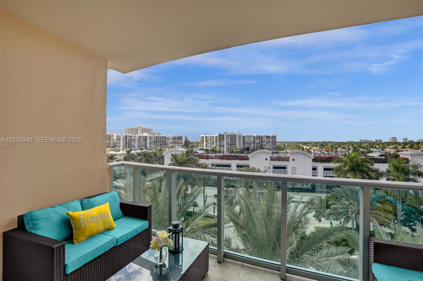 A balcony features wicker furniture with teal cushions and a view of palm trees — 2501 S Ocean Dr, Hollywood FL 33019, HOLLYWOOD, FL