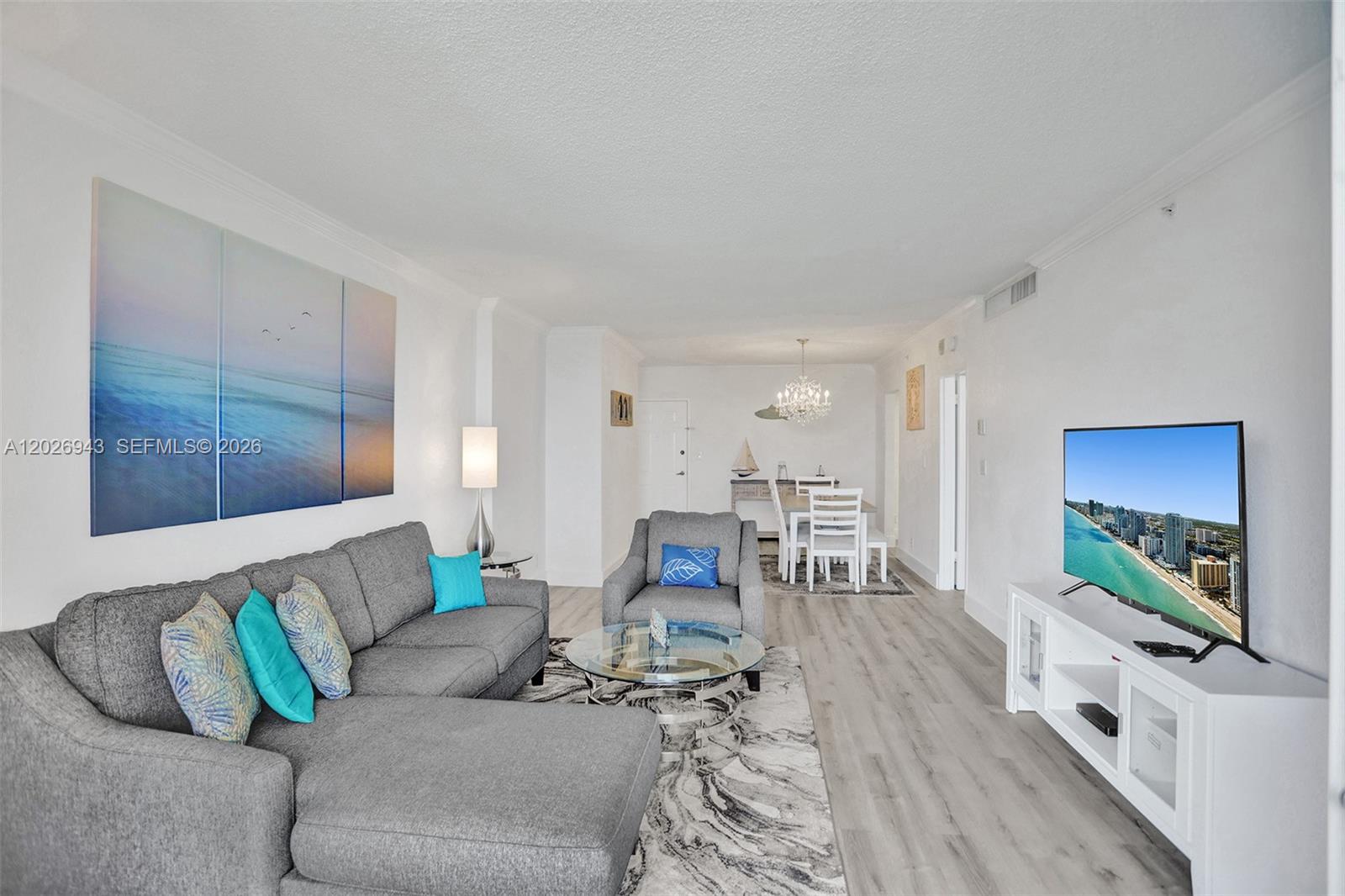 A living room with a grey sectional sofa, glass coffee table, and white media console — 2501 S Ocean Dr, Hollywood FL 33019, HOLLYWOOD, FL
