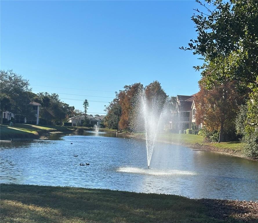 A water fountain sprays in the center of a pond surrounded by trees and buildings — 4126 CENTRAL SARASOTA PARKWAY UNIT 2011, SARASOTA, FL